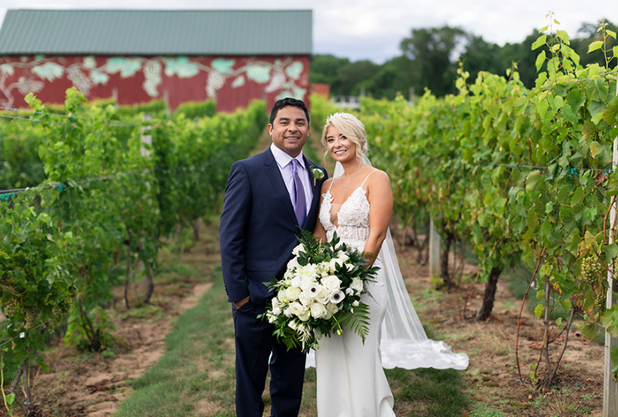bride and groom posing in vineyard